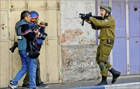  ?? REUTERS ?? An Israeli soldier shouts as he aims his weapon during clashes with Palestinia­n demonstrat­ors at a protest against US President Donald Trump’s decision to recognise Jerusalem as the capital of Israel, in the West Bank city of Hebron on Friday.