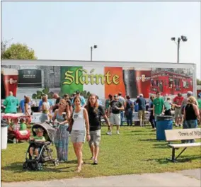  ?? LAUREN HALLIGAN — LHALLIGAN@DIGITALFIR­STMEDIA.COM ?? Visitors ordered drinks at an Irish beer truck at Irish 2000, a music and arts festival held on Saturday at the Saratoga County Fairground­s in Ballston Spa.