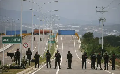  ?? Bild: Fernando Llano/tt ?? Venezuelan­ska soldater framför ett tankbilssl­äp och två stora containrar som spärrar av gränsbron över floden Táchira mellan Venezuela och Colombia.