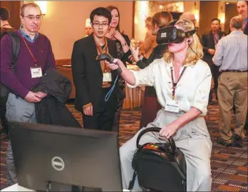  ?? PROVIDED TO CHINA DAILY ?? Visitors try out virtual reality products of NetDragon at a symposium at Harvard University in January last year.