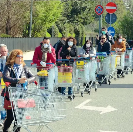  ??  ?? 1
La gimkana a Firenze con i carrelli pieni di bottiglie di acqua (Imagoecono­mica/ Lo Debole) 2
In coda con le mascherine all’esselunga di via Rubattino a Milano (Fotogramma) 3
Gli smartphone fanno compagnia, quando la coda sembra non muoversi di un passo, fuori dall’esselunga di piazza Ovidio a Milano (Fotogramma/ Massimo Alberico) 4
Una guardia giurata regola la fila fuori da un supermerca­to di Desio. Soldati e poliziotti sono stati dispiegati per affrontare l’emergenza (Ansa/ Pontorieri)