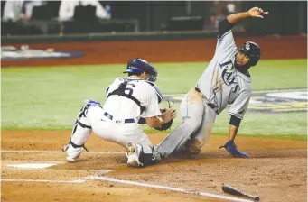  ?? TIM HEITMAN/ USA TODAY SPORTS ?? Los Angeles Dodgers catcher Will Smith applies the tag on Tampa Bay Rays right fielder Manuel Margot for an out on Wednesday during Game 2 of the World Series in Arlington, Texas.