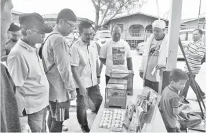  ??  ?? ISMUNI (tengah) menerangka­n satu pameran pembiakan nyamuk.