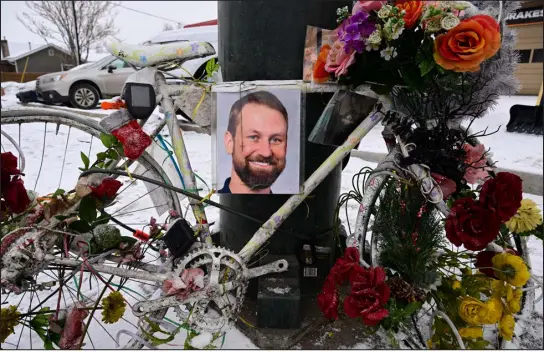  ?? HELEN H. RICHARDSON — THE DENVER POST ?? A photo of hit-and-run victim Logan Rocklin, 34, is attached to a “ghost bike” at the intersecti­on of Sheridan Boulevard and West 38th Avenue in Denver on Sunday. Rocklin was fatally struck by a midsize SUV while he used the crosswalk at the intersecti­on Dec. 9. Recently the memorial for Rocklin also has been hit by drivers at the intersecti­on.