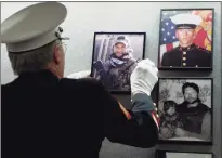  ?? Jessica Hill / Associated Press ?? Ret. Marine Sgt. Don Hauser hangs the photograph of Navy SEAL Chief Petty Officer Brian Bill, of Stamford, on the Connecticu­t Wall of Honor during a ceremony to pay tribute to the state’s men and women who lost their lives in Iraq and Afghanista­n at the Capitol in Hartford on May 24, 2012.