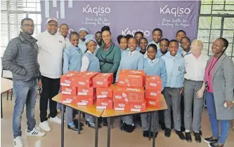  ?? ?? SCHOOL shoes handover at Kagiso Senior Secondary School: Modiba Modibe, property manager at Kagiso Mall and community leader Thobela Ngwane, left, with teachers and pupils. | SUPPLIED