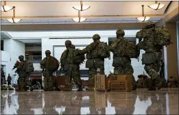  ??  ?? Troops move inside the Capitol Visitor’s Center to reinforce security at the Capitol in Washington Wednesday.