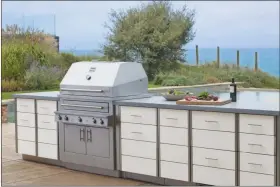  ?? KALZMAZOO OUTDOOR GOURMET VIA THE ASSOCIATED PRESS ?? This photo provided by Kalamazoo Outdoor Gourmet of its Hybrid (charcoal, wood and gas) profession­al grill and Arcadia series cabinetry is shown at a home in Grand Beach, Mich.