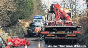  ??  ?? > A recovery lorry arrives at the scene