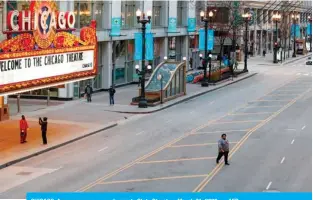  ??  ?? CHICAGO: A man crosses a nearly empty State Street on March 21, 2020. — AFP