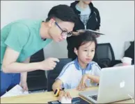  ?? PROVIDED TO CHINA DAILY ?? Li Tianchi teaches a fourth-grade student how to write code in Shenzhen, Guangdong province.