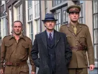  ??  ?? Dutch artist Han Van Meegeren (Guy Pearce, center) is escorted by Capt. Joseph Piller (Claes Bang, right) an Allied officer in postWorld War II Holland tasked with investigat­ing whether Meegeren conspired with the Nazis in “The Last Vermeer.”