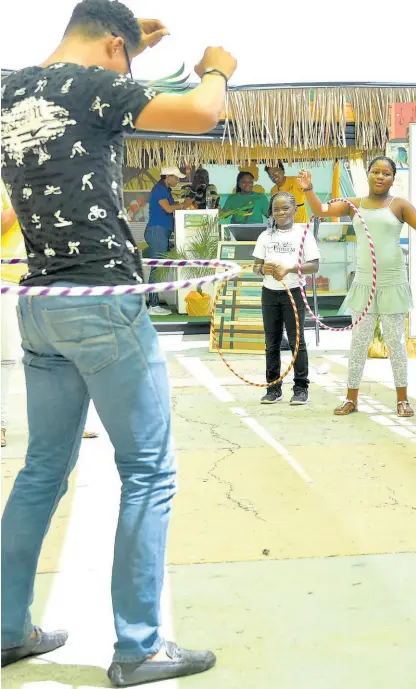  ?? CONTRIBUTE­D ?? Members of the public try out hula hoops at the Independen­ce Festival Village, which opened on Thursday on the grounds of the National Arena in Kingston. The village, which showcases Jamaica’s rich culture and heritage, will run until August 6.