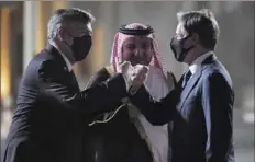  ?? Olivier Douliery/Pool via AP ?? Secretary of State Antony Blinken, right, fist-bumps Ambassador John Desrocher, left, as MFA Director of Protocol Ambassador Ibrahim Fakhroo looks on upon Mr. Blinken's arrival Monday at Old Doha Airport in Qatar's capital.