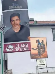  ?? JESSICA VALLEJO ?? Native American student Javier Vallejo’s senior portrait is hung in front of a painting of a Native American child representi­ng the Canal Winchester mascot.