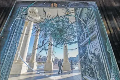  ?? AP PHOTO/J. SCOTT APPLEWHITE ?? Shattered glass from the attack on Congress by a pro-Trump mob is seen in the doors leading to the Capitol Rotunda on Jan. 12 in Washington.