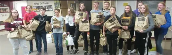  ?? Photos by Heather Cameron ?? Left: Grade 9 students and staff from St. Joseph School bring food out and help load it into the Drive Away Hunger trailer. Below: Elder Pound and Elder Schmidt (right) from the Church of Jesus Christ of LatterDay Saints bring member donations to the Coaldale Food Bank.