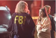  ?? MARK J. TERRILL/AP ?? An FBI agent talks to a potential witness Thursday near the scene of a mass shooting in a country dance bar in Thousand Oaks, Calif.