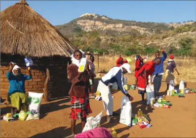  ??  ?? Some of the beneficiar­ies collecting the food hampers donated by former Warriors skipper and Kaizer Chief defensive linkman Willard Katsande to 200 families in his rural home, Mtoko yesterday