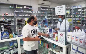  ??  ?? Pharmacist Ziad Jomaa sells medicine to a customer in his pharmacy in Bchamoun village outside of Beirut, Lebanon, on Oct. 28.