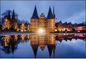  ?? MICHAEL PROBST — THE ASSOCIATED PRESS ?? The medieval Holstentor is reflected in water in Luebeck, Germany, Monday.