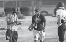  ?? ANABEL ORTIZ ?? Goodyear Desert Edge football co-head coaches Mark Carter, left, and Marcus Carter, middle, direct practice.