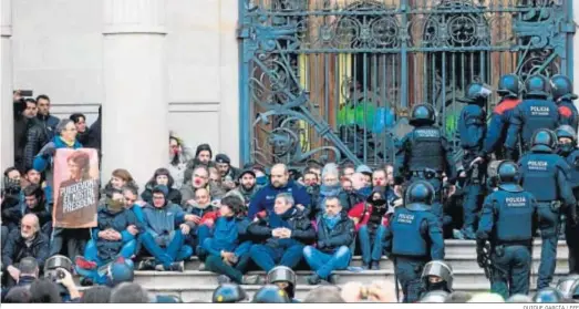  ?? QUIQUE GARCÍA / EFE ?? Agentes de los Mossos desalojan a las decenas de personas ante el Tribunal Superior de Justicia de Cataluña en febrero de 2018.