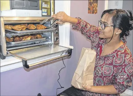  ?? FRAM DINSHAW/ TRURO NEWS ?? Nive and Hemlal are well-known locally for their butter chicken samosas. The  rst batch from The India Hut came out of the oven on Wednesday, courtesy of Nive Krishnan.