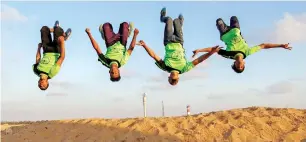  ?? AFP ?? Four members of a parkour team flip and twist their way around the site of the camp of what Palestinia­ns have dubbed the Great March of Return. —