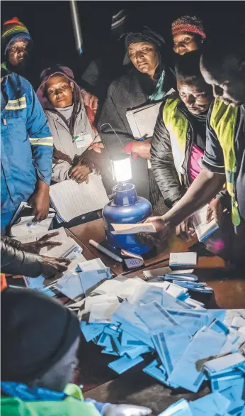  ?? Picture: AFP ?? Observers check votes at a polling station in a suburb of Zimbabwe’s capital Harare.