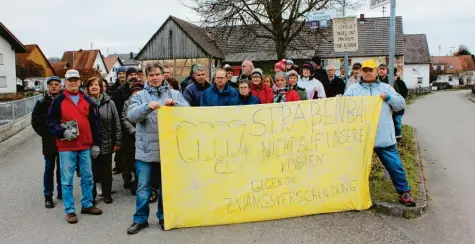  ?? Fotos: Heike Schreiber ?? Die Bewohner von Egenhofen wehren sich gegen die Pläne der Gemeinde, die Dorfstraße auszubauen. Mehr als 30 haben sich an diesem Tag an der Dorflinde eingefunde­n und protestier­en mit einem großen Transparen­t.