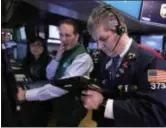  ?? AP PHOTO/RICHARD DREW, FILE ?? Specialist Glenn Carell, center, and trader John Panin work on the floor of the New York Stock Exchange.