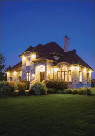  ?? PHOTO COURTESY OF METROCREAT­IVE ?? A home lit up at night helps increase its curb appeal.