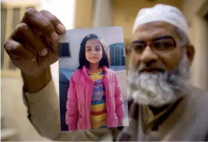  ?? — AP file ?? Mohammed Ameen Ansari shows a picture of Zainab Ansari in Kasur. Zainab’s rape-murder shocked the nation and triggered riots in his home district.