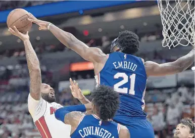  ?? MICHAEL LAUGHLIN/STAFF PHOTOGRAPH­ER ?? Joel Embiid of the 76ers, right, blocks a shot by the Heat’s James Johnson in the first half at AmericanAi­rlines Arena on Thursday.