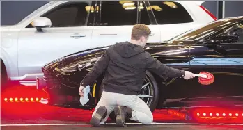  ?? GERRY KAHRMANN ?? Oliver Auer dusts an Aston Martin DB 11 on display at the Vancouver Internatio­nal Auto Show held at Vancouver Convention Centre West last month. Plans are already underway for next year’s event.