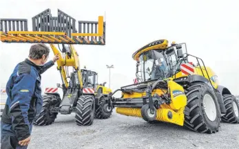  ?? FOTO: FELIX KÄSTLE ?? Live in Ravensburg: Nutzfahrze­uge von New Holland kommen auf dem Gelände vor der Oberschwab­enhalle an. Pascal Waibel von Neyer Landtechni­k weist die Fahrer ein.