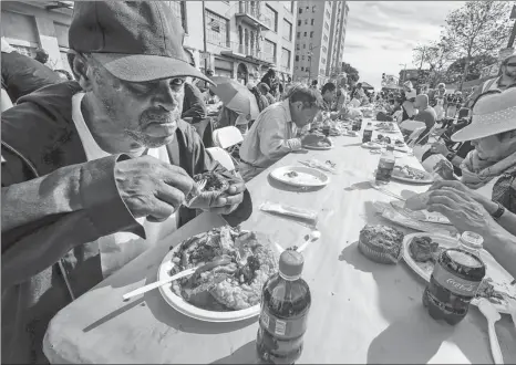  ?? ZHAO HANRONG / XINHUA ?? Homeless people have lunch offered by charities on Thanksgivi­ng Day in Los Angeles.