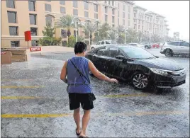  ?? K.M. Cannon Las Vegas Review-journal @Kmcannonph­oto ?? Keith Carbullido pulls up the car for his wife, Rosa Carbullido, in a downpour Wednesday at Green Valley Ranch Resort. About three-quarters of an inch of rain hit the southern Las Vegas Valley, with more possible for the valley on Thursday.