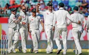  ?? – Reuters ?? FOUR-FOR: Australia’s Nathan Lyon, second left, celebrates with his teammates after dismissing India’s captain Ajinkya Rahane during the second day of their fourth Test match at HPCA Stadium in Dharamsala on Sunday.