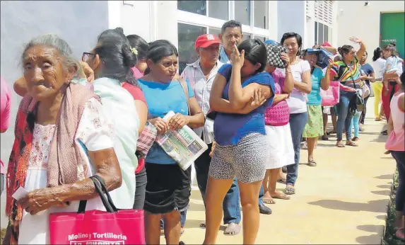  ??  ?? Beneficiar­ios que la mañana de ayer martes hicieron largas filas bajo el sol para recibir un paquete de tres despensas del programa Asistencia Alimentari­a Familiar (Pasaf) que otorga el DIF municipal de Tizimín