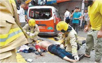  ?? AFP-Yonhap ?? Rescuers attend a taxi driver who was beaten by protesters after his car ran over various protesters in a crowd enclosing the taxi during the Anti-ERO (Emergency Regulation­s Ordinance) demonstrat­ion against a newly imposed law banning face masks in public in Hong Kong, Sunday.