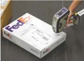  ?? AP FILE PHOTO ?? A worker scans packages at a FedEx facility. A new Chattanoog­a distributi­on center is opening at a cost of about $30 million.