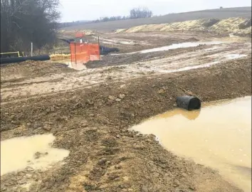  ?? Department of Environmen­tal Protection ?? In this inspection photo, muddy runoff from a CNX Resources Corp. pipeline constructi­on site in North Mahoning, Indiana County, is channeled through a pipe toward a stream on March 29.