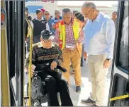  ??  ?? GOING TO TOWN: Brian Currin, in the wheelchair, is assisted by municipal infrastruc­ture and engineerin­g executive director Dr Walter Shaidi and Nelson Mandela Bay mayor Athol Trollip to get on the IPTS bus in Cleary Park