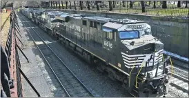  ?? (AP PHOTO/GENE J. PUSKAR, FILE) ?? In this March 26, 2018, file photo, a Norfolk Southern freight train rolls through downtown Pittsburgh. Norfolk Southern Corp.’s second-quarter profit fell 46% as the railroad hauled 26% less freight because of the coronaviru­s outbreak’s impact on the economy. The railroad said Wednesday, July 29, 2020 it earned $392 million, or $1.53 per share, during the quarter.