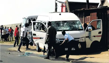  ?? /SANDILE NDLOVU ?? Disgruntle­d residents of KwaThema stone a minibus taxi owned by double murder accused Themba Ndlozi. Ndlozi appeared in court yesterday.
