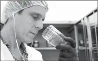  ?? AP/RICARDO ARDUENGO ?? Juan Manuel Rodriguez, an investor at Natural Ventures, smells a jar of marijuana final product, in Caguas, Puerto Rico late last month.