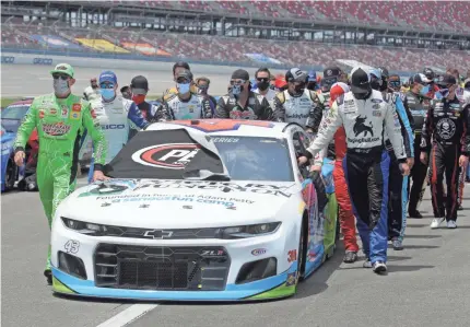  ?? CHRIS GRAYTHEN/GETTY IMAGES ?? NASCAR drivers push the Victory Junction Chevrolet, driven by Bubba Wallace, to the front of the grid as a sign of solidarity with the driver before the GEICO 500 at Talladega on Monday. He finished 14th.