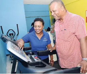  ??  ?? AT LEFT: Pilar Rodriques, founder and manager of Alma’s Integrated Cleaning Solutions, helps her client Rodney Spence to adjust this exercise machine.